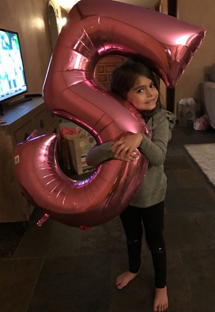 Liv hugging her "5" balloon